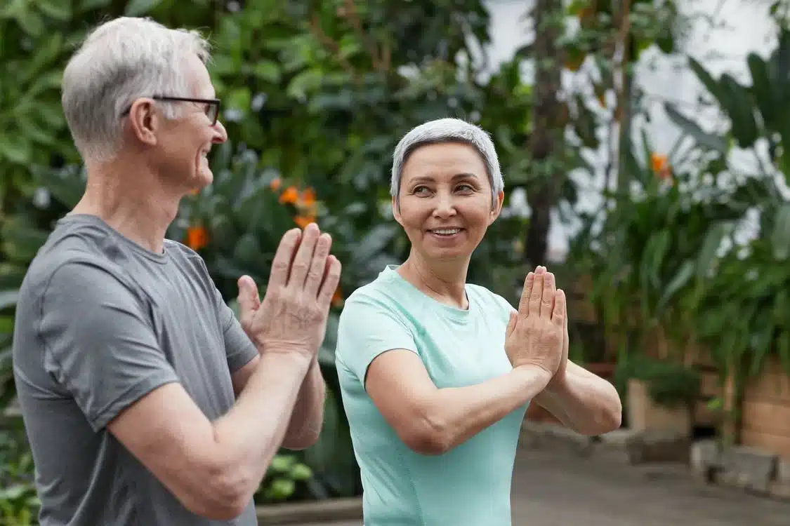 Senior couple yoga green