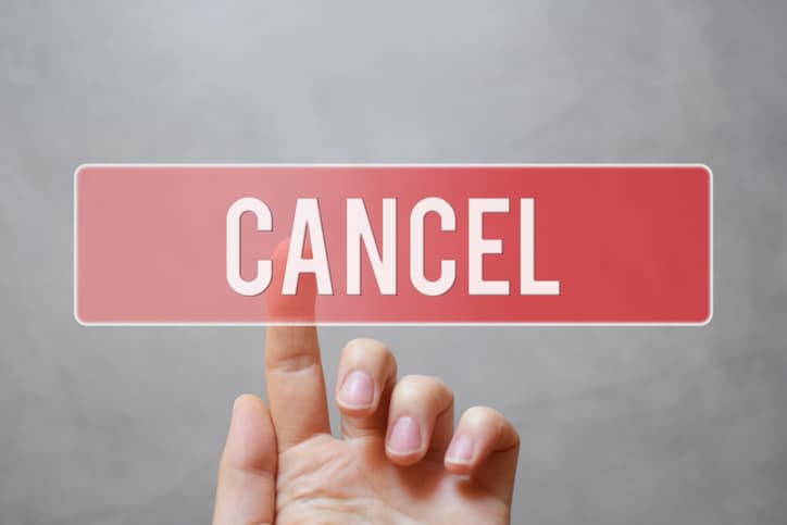 Cancel – hand pressing red transparent button