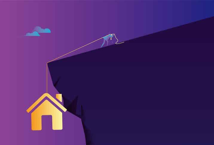 Business man tries hard not to let the house fall off the cliff Housing Struggle Cliff Decline