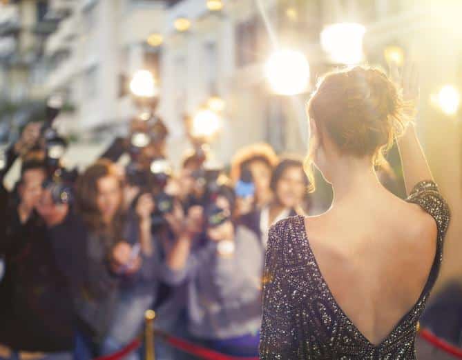 Celebrity waving at paparazzi photographers at event Celebrity Photo Red Carpet