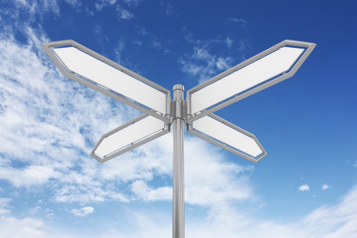 Four way signpost with sky