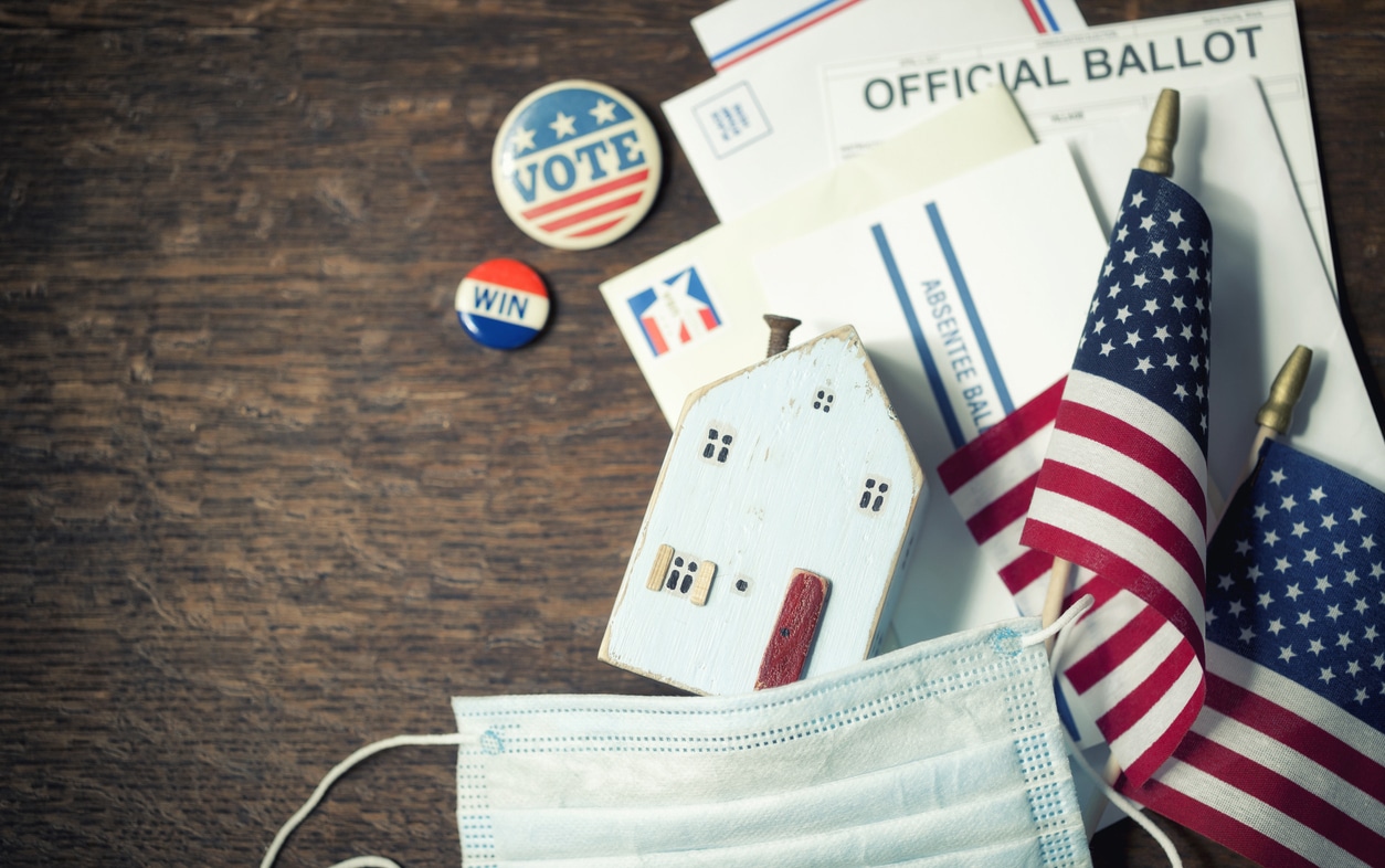 House model and US flag atop ballot affordable housing 2022 election House model and US flag atop ballot affordable housing 2022 election