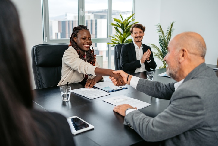 Two Business Colleagues Shaking Hands To Seal The Deal In The Office