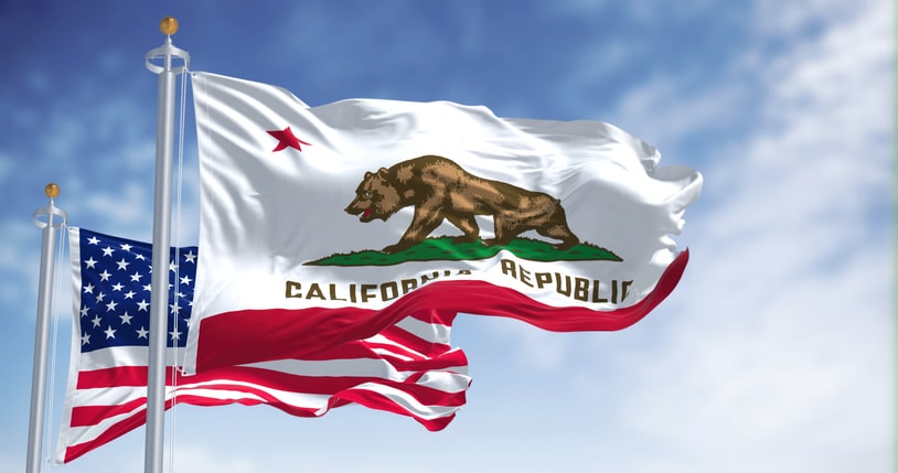 The California state flag waving along with the national flag of the United States of America California Home Purchase