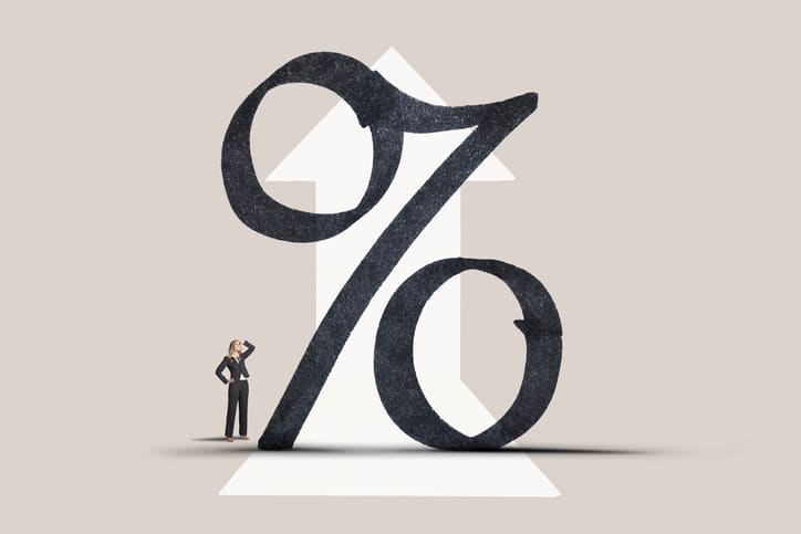 Woman Looking up At Riging Interest Rate Symbol