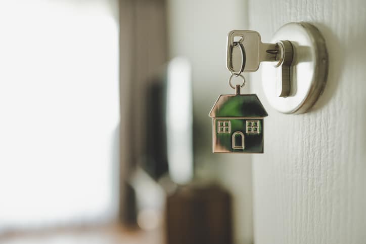 Open the door and door handle with a key and a keychain shaped house. Property investment and house mortgage financial real estate concept Housing Market turning the Corner rates Down Sales Up