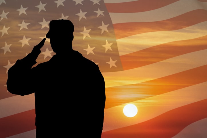 Soldier silhouette saluting gesture at sunset