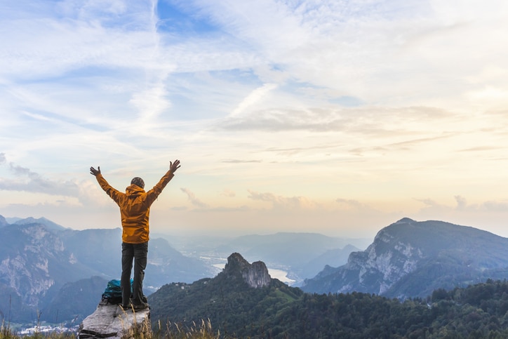 Happy hiker with raised arms on top of the mountain Mountain Peak Hike Summit Sales Goals