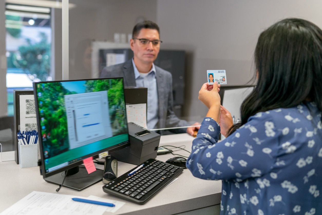 Bank teller checking customer’s driver’s license