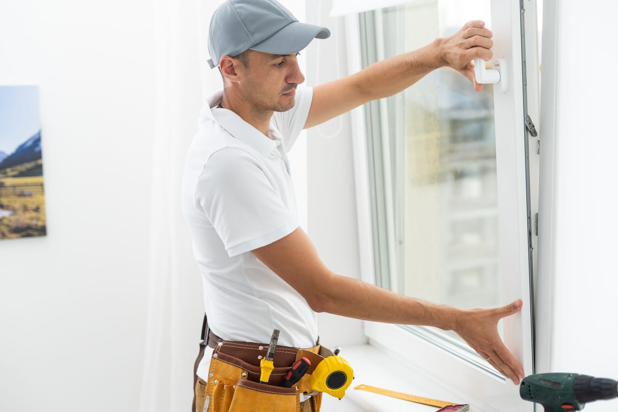 Master’s work. Close-up of young handyman setting new windows at the appartment