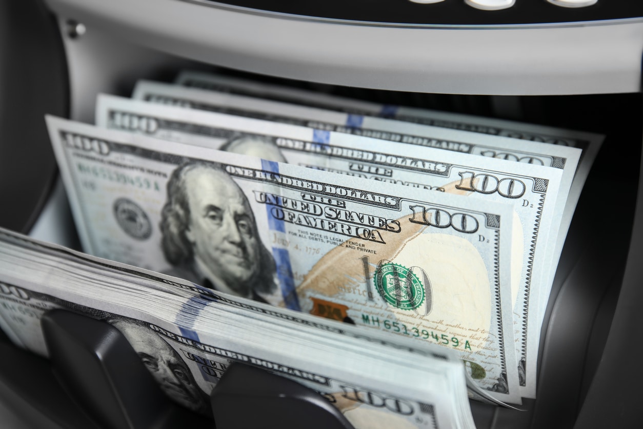 Modern electronic bill counter with money, closeup