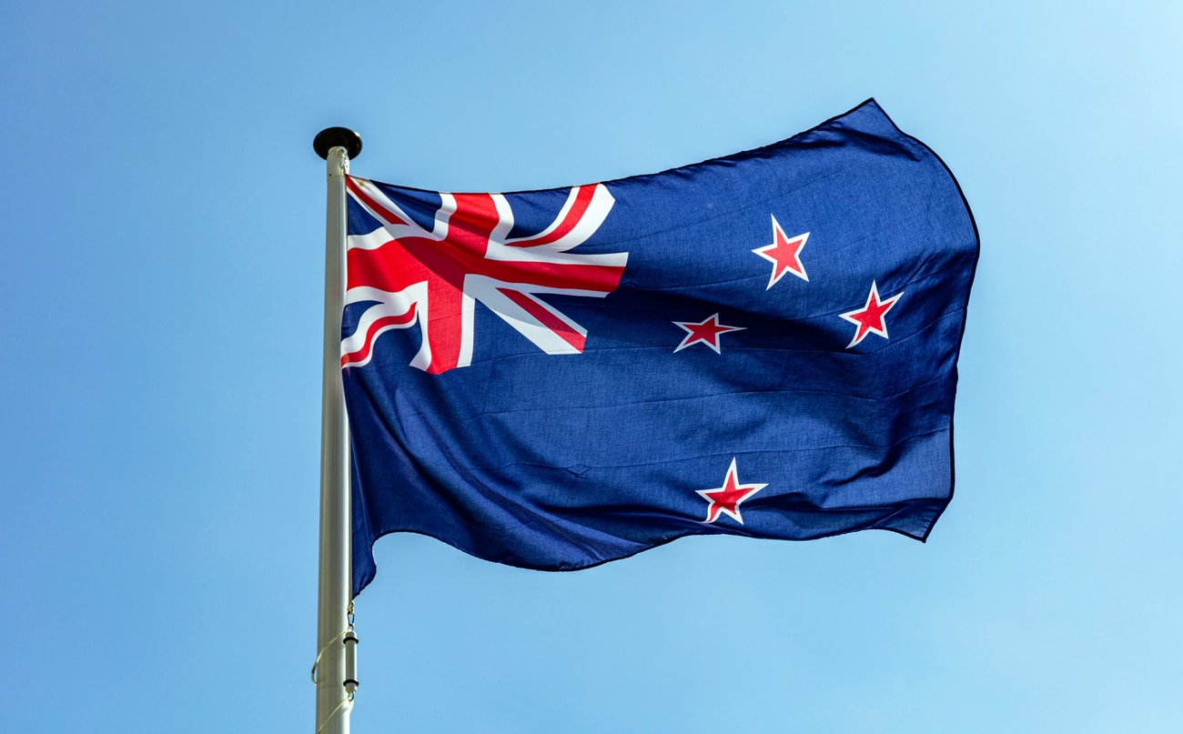 New Zealand flag waving against clear blue sky